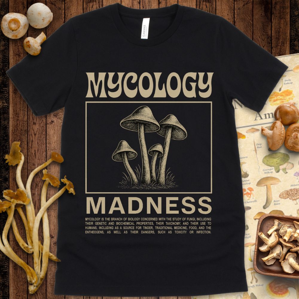 Vintage-style graphic T-shirt design featuring detailed mushrooms with the text “Mycology Madness” and a description of mycology.