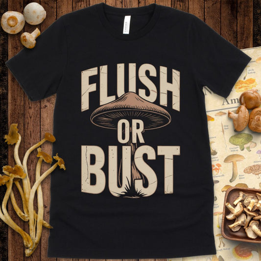 Bold vintage-style t-shirt design with the phrase “Flush or Bust” over a large illustrated mushroom in cream and brown on a black background