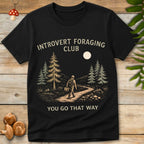 Vintage-style t-shirt design of a solo hiker in the woods carrying a basket, with the phrase “Introvert Foraging Club – You Go That Way”