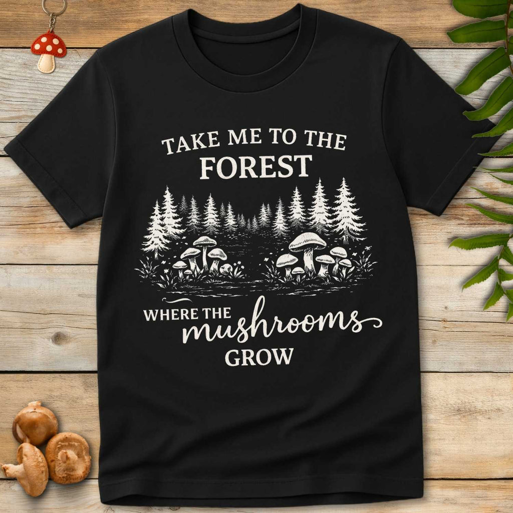 T-shirt design with mushrooms in a forest clearing and text that reads “Take Me to the Forest Where the Mushrooms Grow” in vintage-style font