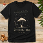 Mushroom Rain Tee featuring a frog sitting under a giant mushroom during rainfall with cozy woodland cottagecore artwork.