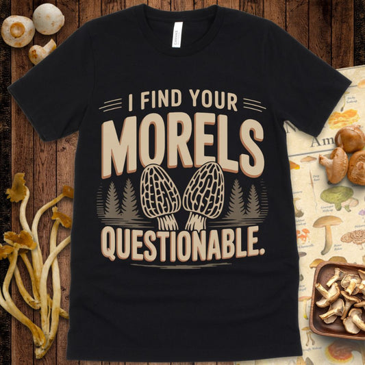 T-shirt design with the phrase “I Find Your Morels Questionable” featuring two illustrated morel mushrooms and pine trees