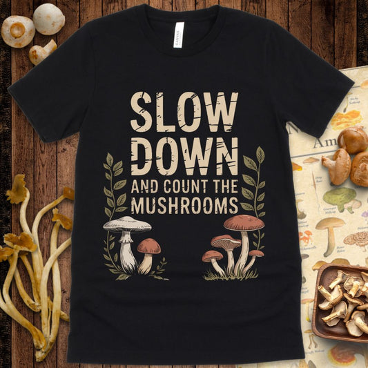 Text reads “Slow Down and Count the Mushrooms” with hand-drawn mushrooms and leafy plants on either side