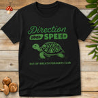 Green vintage-style t-shirt design featuring a tortoise with forest symbols on its shell and the phrase “Direction Over Speed – Out-of-Breath Foragers Club”