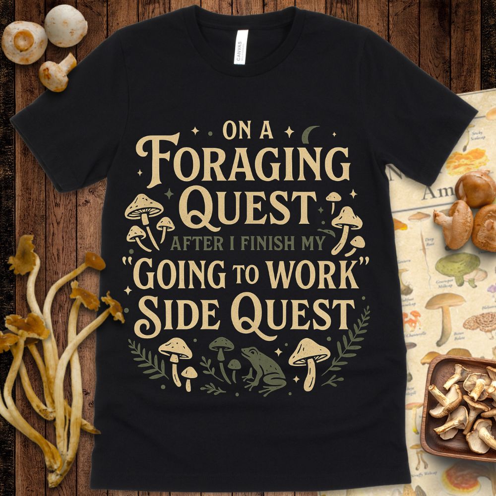 Whimsical mushroom and frog design with fantasy text that reads “On a Foraging Quest After I Finish My ‘Going to Work’ Side Quest” on a forest-themed tee.
