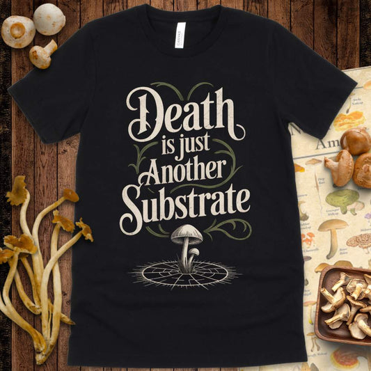 T-shirt design with the phrase “Death is Just Another Substrate,” featuring vintage typography, vines, and mushrooms growing from cracked soil