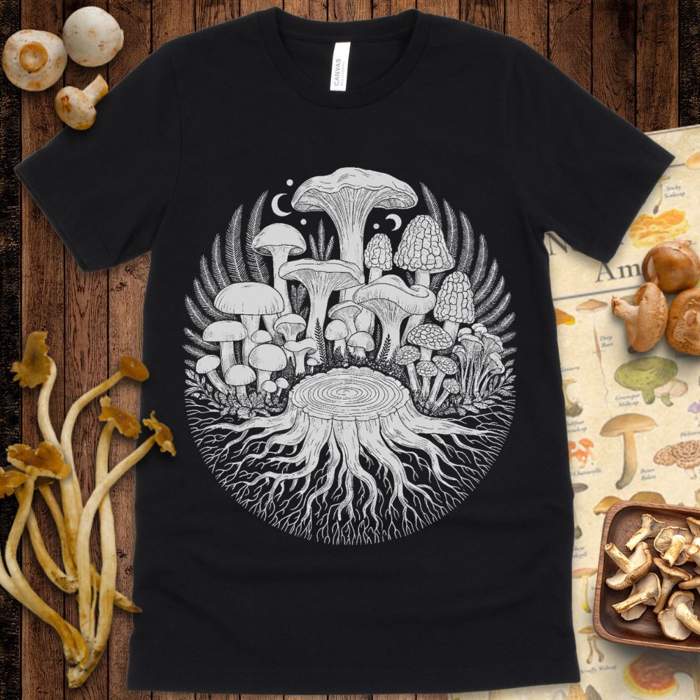 Intricate black and white illustration of mushrooms growing from a tree stump with roots, ferns, and moons in a circular forest-inspired design