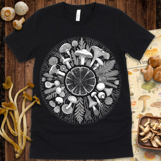 Detailed black and white mandala of mushrooms, leaves, roots, and a central tree ring forming a circular nature-inspired design