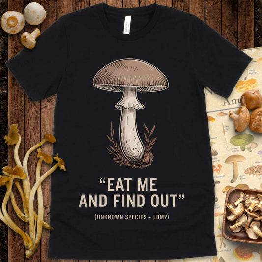 T-shirt design with a brown mushroom above the phrase “Eat Me and Find Out” and “Unknown Species – LBM?” beneath