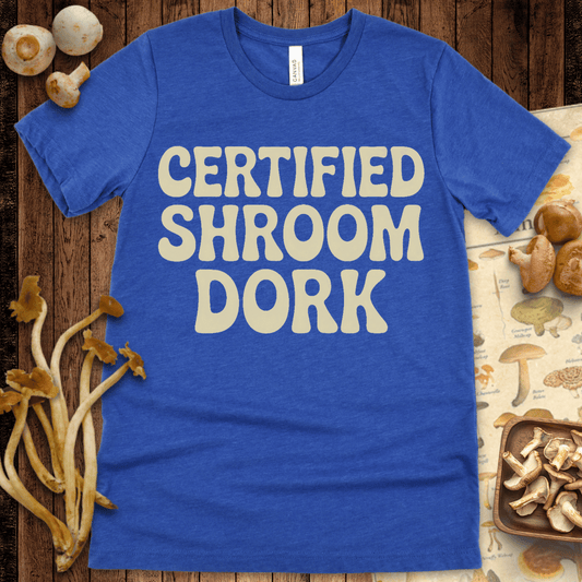 Retro-style t-shirt with bold groovy text reading "Certified Shroom Dork" in playful cream lettering on a black background