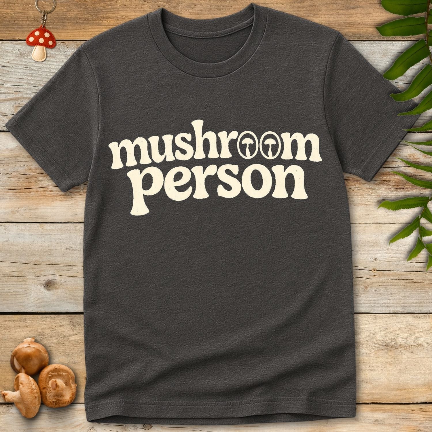 Bold retro typography reading “mushroom person” with small mushroom icons inside the lettering on a grey shirt