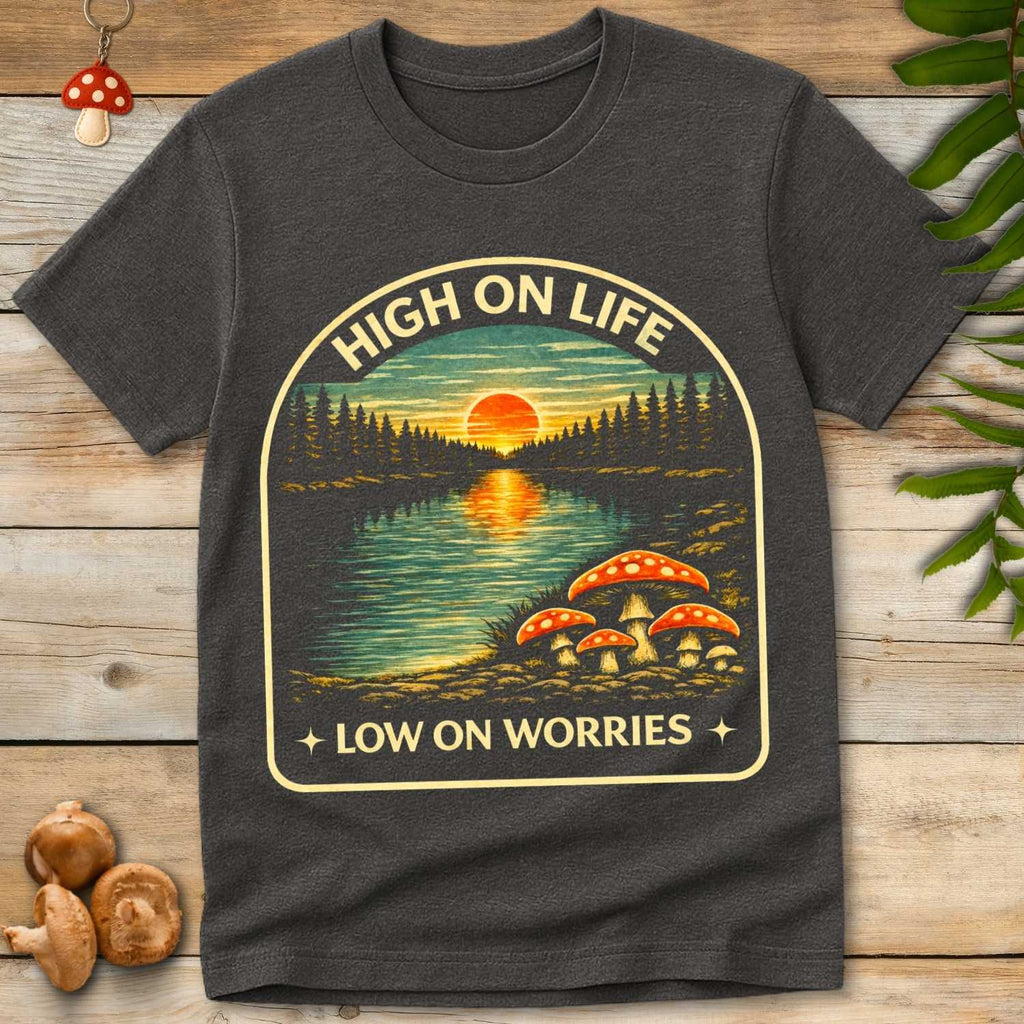 Vintage forest lake sunset with red spotted mushrooms and the phrase “High On Life Low On Worries”.