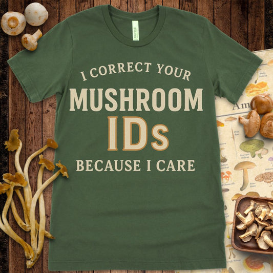 Graphic t-shirt with the phrase “I Correct Your Mushroom IDs Because I Care” in cream and brown vintage-style text on black background