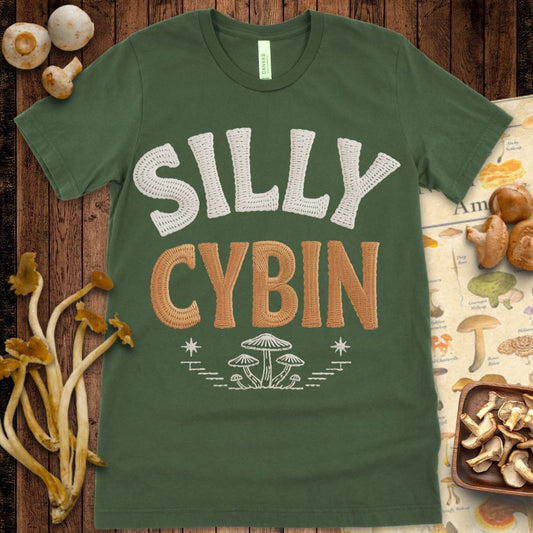 Textured faux-embroidered “Silly Cybin” text in cream and brown with embroidered mushroom illustration below on black background.