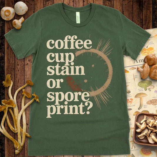 Grungy T-shirt design showing a coffee cup stain with the phrase “coffee cup stain or spore print?” in bold vintage font