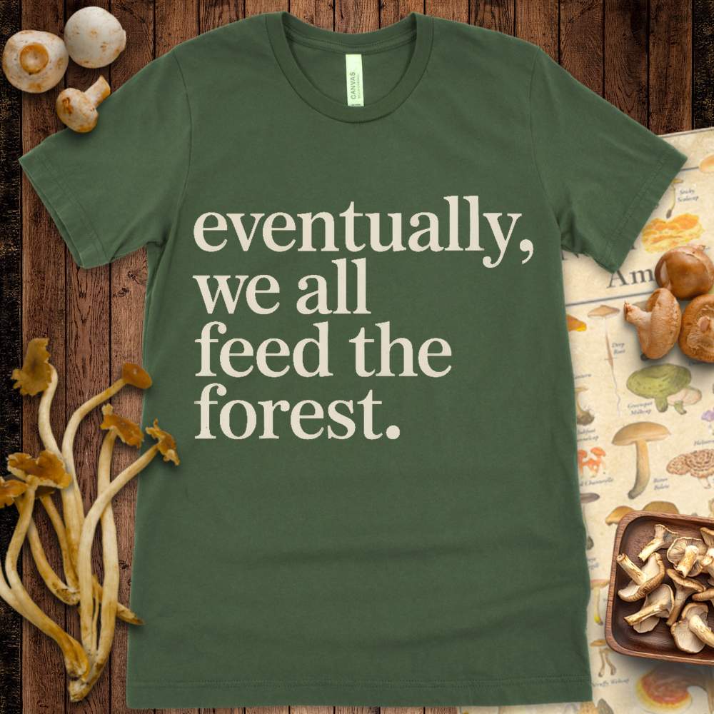 Minimalist T-shirt design with the phrase “Eventually, we all feed the forest” in vintage-style serif font