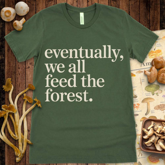 Minimalist T-shirt design with the phrase “Eventually, we all feed the forest” in vintage-style serif font