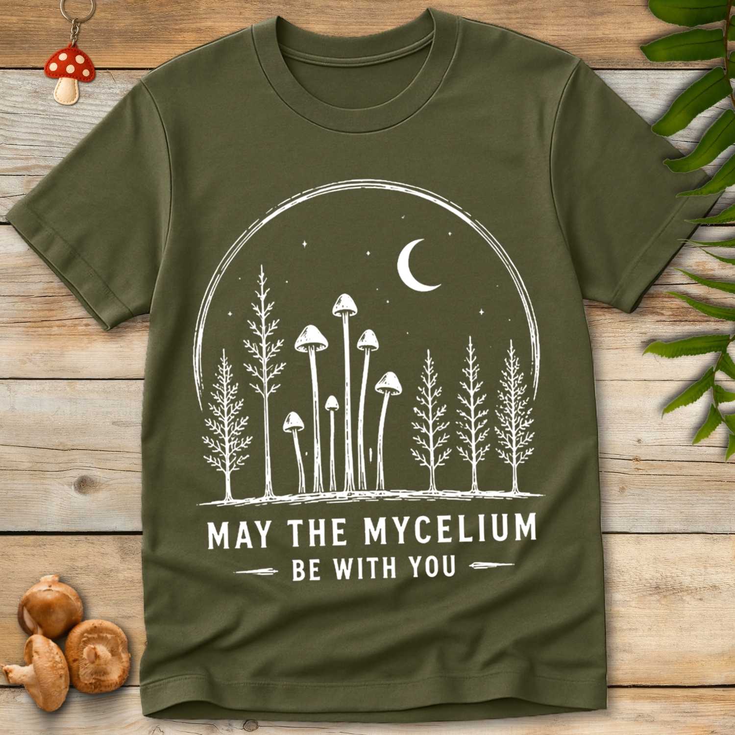 Mycelium With You Tee featuring woodland mushrooms, moonlit forest trees, stars, and the phrase “May The Mycelium Be With You.”