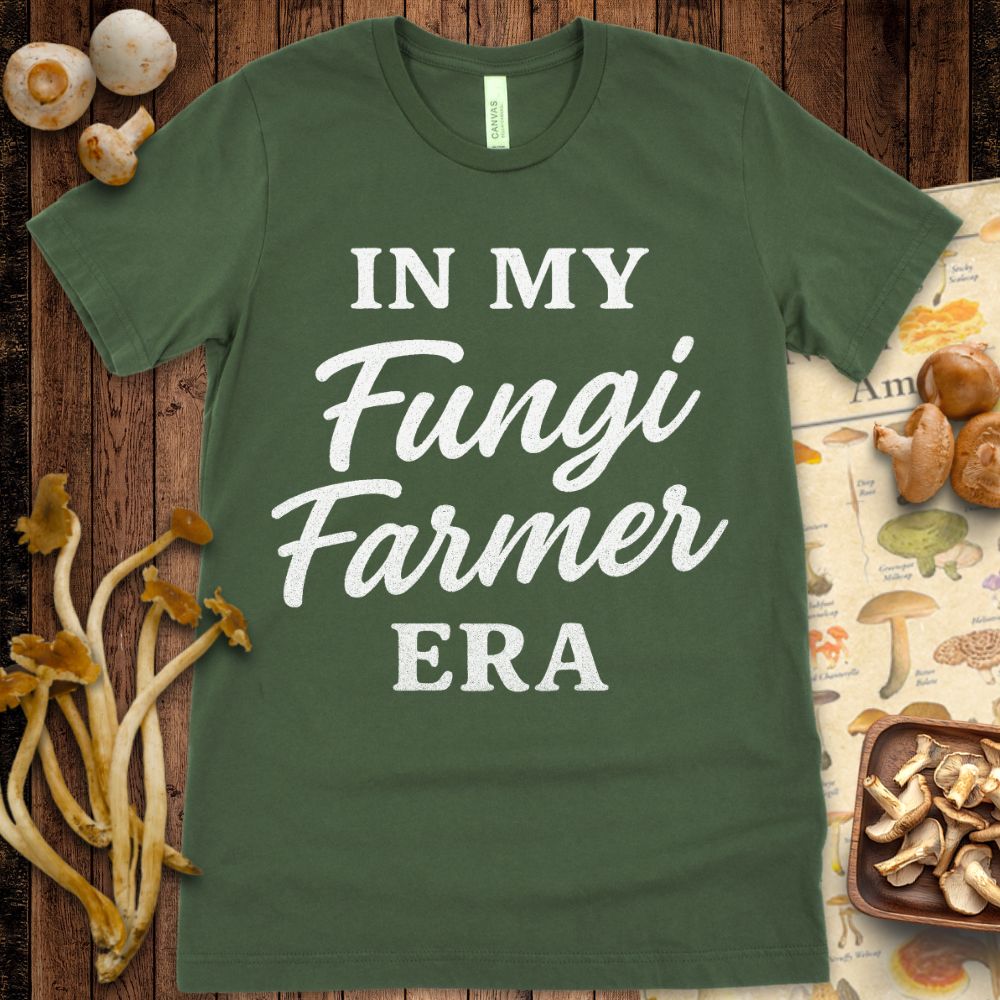 Black T-shirt design with mixed bold and script white text reading “In My Fungi Farmer Era”