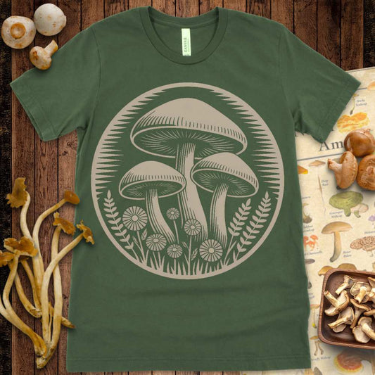 Vintage mushroom and wildflower illustration with fern details in a circular design on a green T-shirt