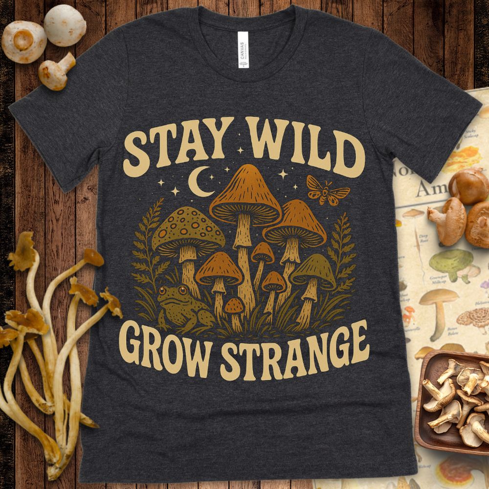 Retro-style illustration of mushrooms, a frog, moth, crescent moon, and stars with the phrase “Stay Wild, Grow Strange” in bold vintage lettering.