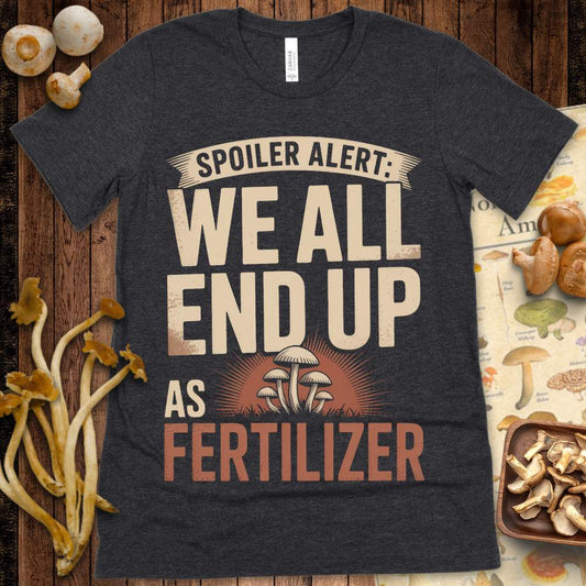 Vintage-style T-shirt design with the phrase “Spoiler Alert: We All End Up As Fertilizer” and mushrooms growing in front of a sunburst