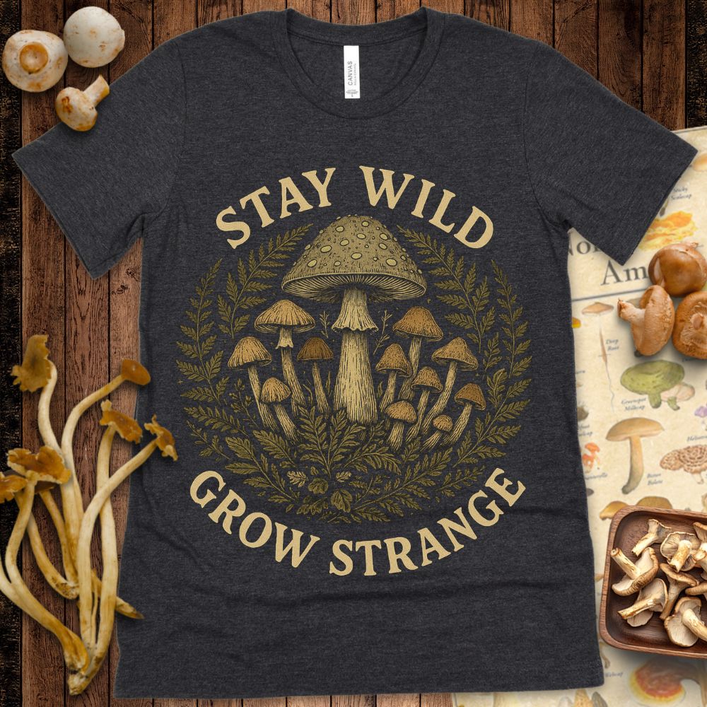 Detailed illustration of various mushrooms and ferns arranged in a circular botanical style with the text “Stay Wild Grow Strange” surrounding the artwork.