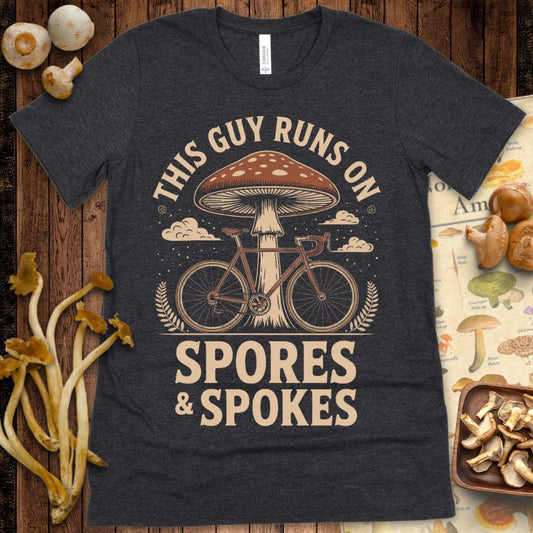 Vintage-style graphic of a road bike beneath a large spotted mushroom with the text “This Guy Runs on Spores & Spokes”
