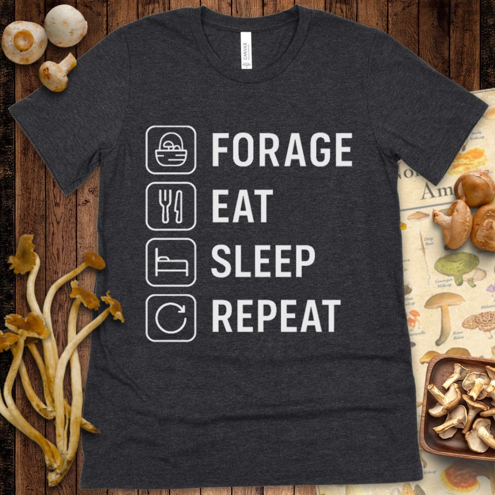 Black t-shirt with white line-art icons and text reading “Forage, Eat, Sleep, Repeat” in a vertical format.