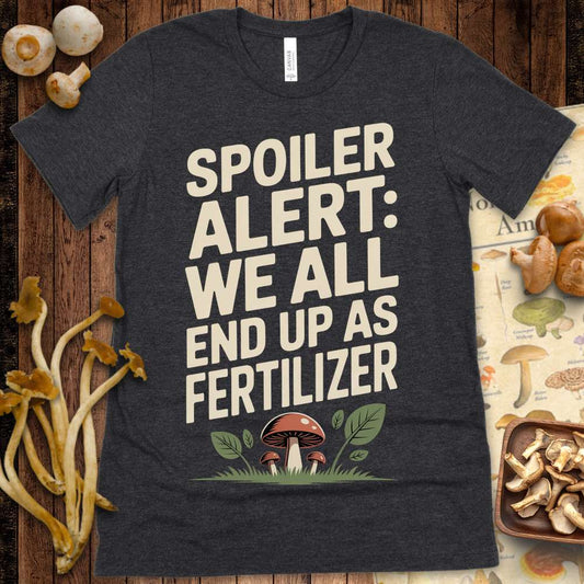 Graphic t-shirt design showing red mushrooms with the phrase “Spoiler Alert: We All End Up As Fertilizer” in bold letters