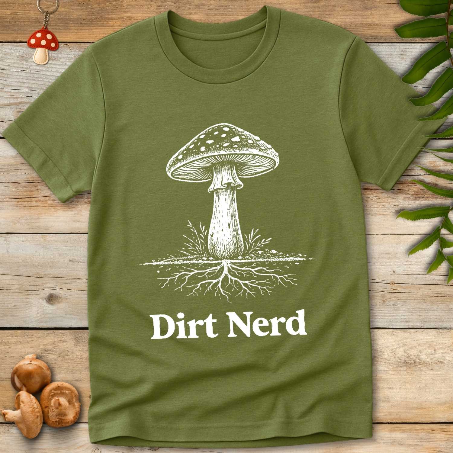 green shirt with white mushroom illustration with visible root system and bold text reading “Dirt Nerd”
