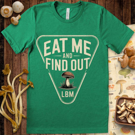 Triangle-shaped t-shirt graphic with a mushroom and the words “Eat Me and Find Out – LBM” in bold lettering