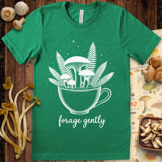 Line art illustration of mushrooms and ferns growing out of a teacup with the words “forage gently” below on a black background