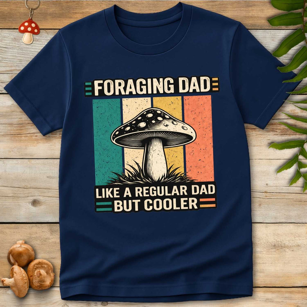 Vintage-style shirt reading “Foraging Dad Like a Regular Dad But Cooler” with a mushroom graphic and retro sunset color background.