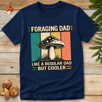 Vintage-style shirt reading “Foraging Dad Like a Regular Dad But Cooler” with a mushroom graphic and retro sunset color background.