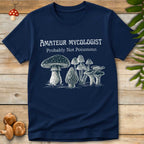 Illustrated T-shirt design featuring the text “Amateur Mycologist – Probably Not Poisonous” above a group of various mushrooms in a vintage sketch style.