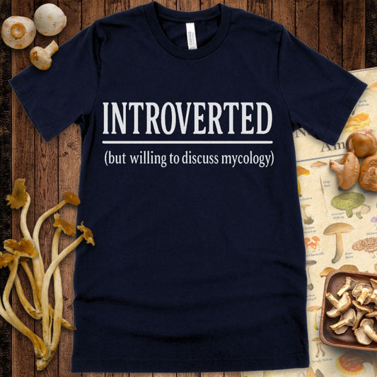 Black T-shirt design with white text reading “INTROVERTED (but willing to discuss mycology)” in bold and serif fonts