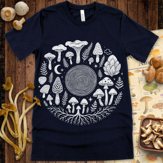 Stippled mandala design of mushrooms, tree rings, crescent moon, ferns, and mycelium roots in a white-on-black circular composition.