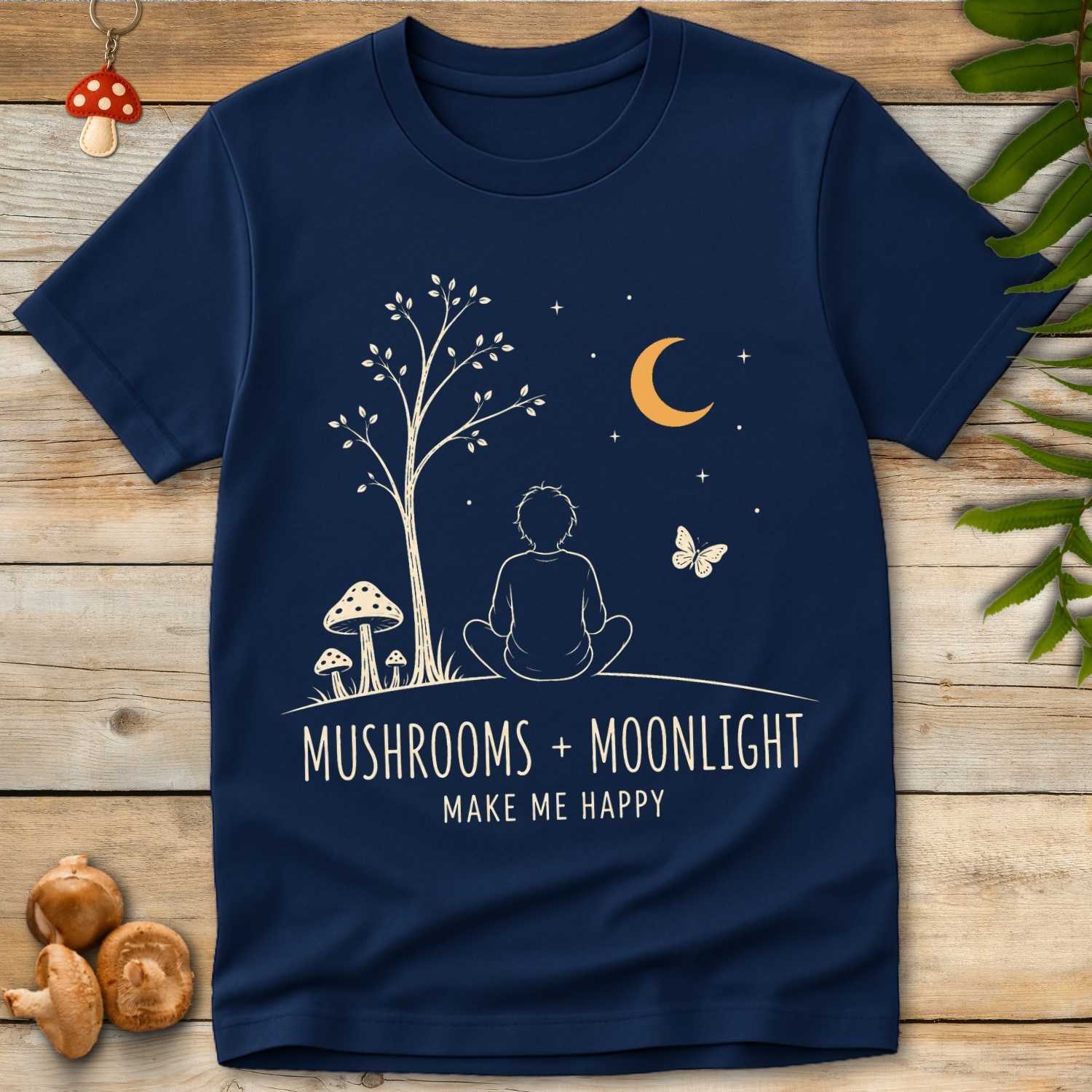 Boy Moonlight Tee featuring a seated boy under a crescent moon with woodland mushrooms, stars, and peaceful cottagecore forest artwork.