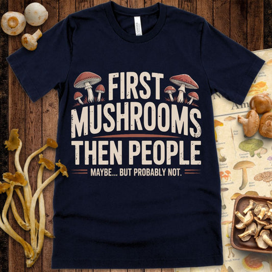 T-shirt design with bold distressed text reading “First Mushrooms Then People… Maybe But Probably Not” surrounded by illustrated mushrooms
